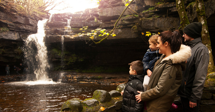 Family of Four overlooking Summer Force Waterfall inside Gibson's Cave